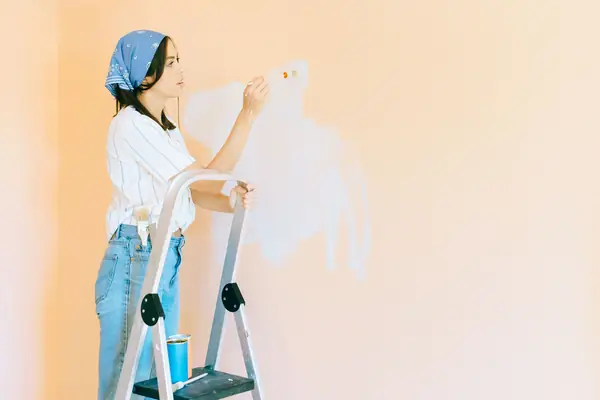 Interior painting in Knoxville: painter on a stepladder rolling a wall